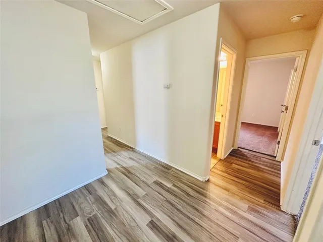 a view of a room with wooden floor and door