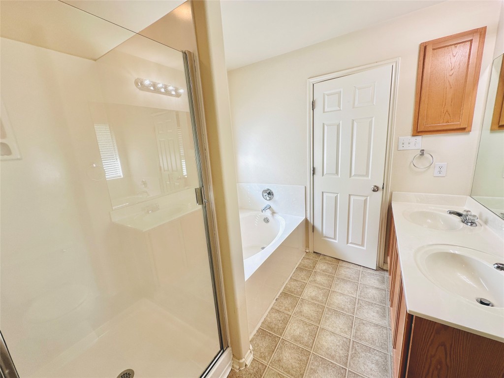 2205 Boyds Way Austin, TX 78748 - Photo 37 of 40 a bathroom with a sink a mirror and a bathtub