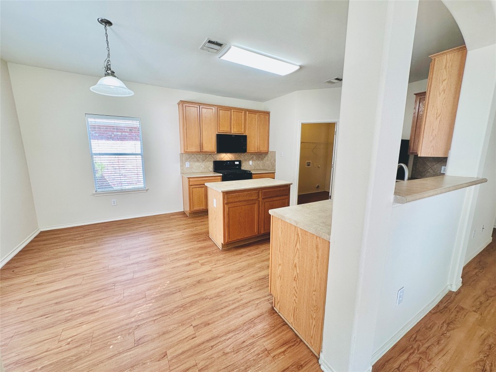 2205 Boyds Way Austin, TX 78748 - Photo 7 of 40 a kitchen with a refrigerator a stove top oven and wooden floor