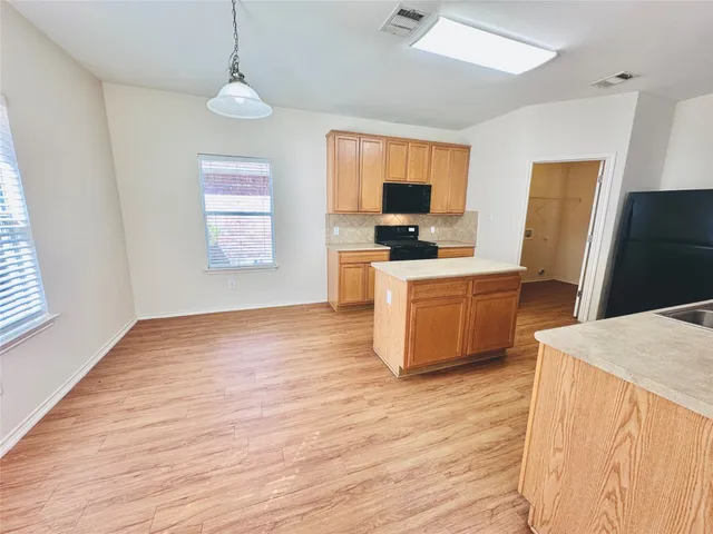 a kitchen that has a microwave a sink and a stove in it