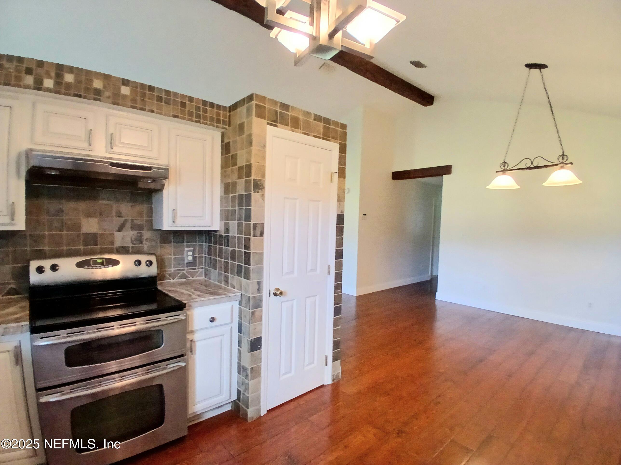 8905 Reid Packing House Road Hastings, FL 32145 - Photo 18 of 40 a kitchen with granite countertop a stove and cabinets