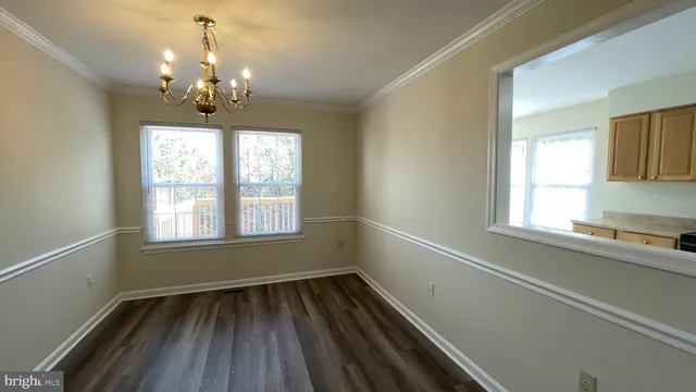 a view of a room with wooden floors and chandelier