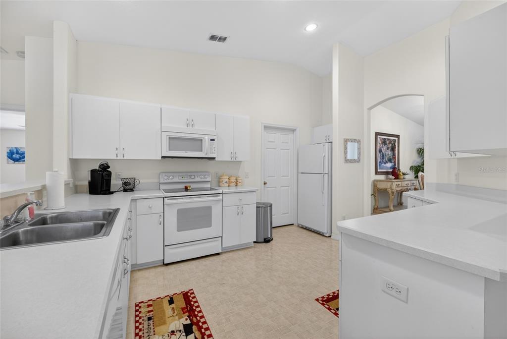 6032 Southwest 103rd Loop Ocala, FL 34476 - Photo 3 of 28 a kitchen with stainless steel appliances a stove a sink and a refrigerator