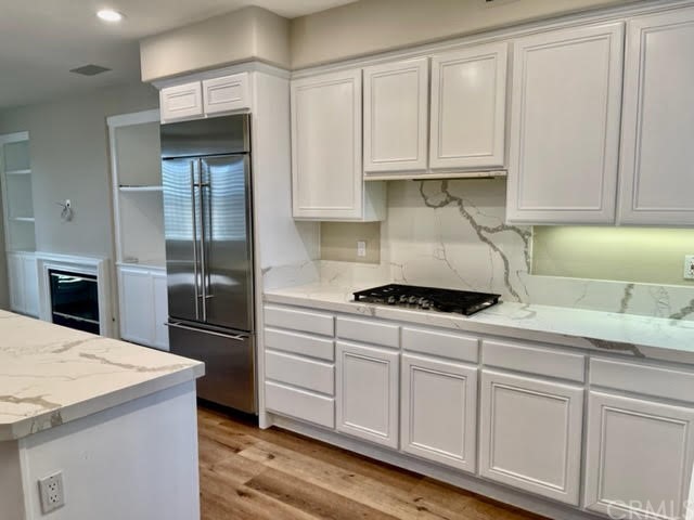 19 Avignon Newport Coast, CA 92657 - Photo 4 of 14 a kitchen with stainless steel appliances granite countertop a stove a refrigerator and a white cabinets
