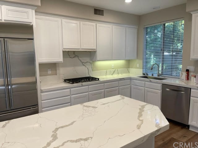 19 Avignon Newport Coast, CA 92657 - Photo 5 of 14 a kitchen with a refrigerator and white cabinets