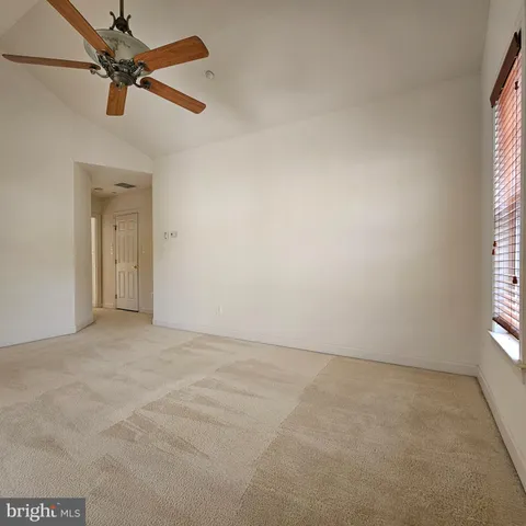 an empty room with a window and a fan