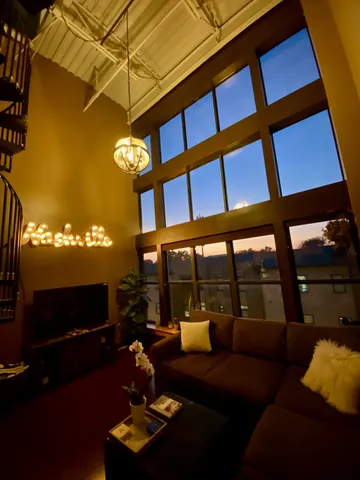 a living room with furniture a lamp and a floor to ceiling window
