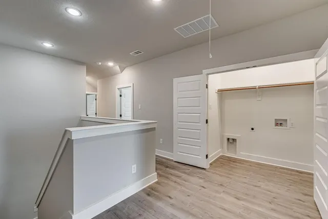 an empty room with wooden floor and cabinet