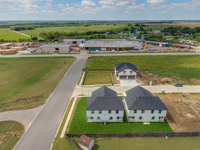 an aerial view of a house with a garden and lake view