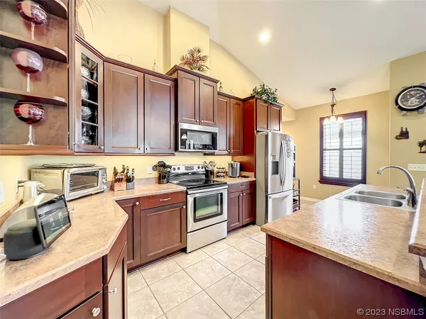 a kitchen with granite countertop a refrigerator and a stove top oven
