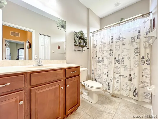 a spacious bedroom with a large bed and a chandelier