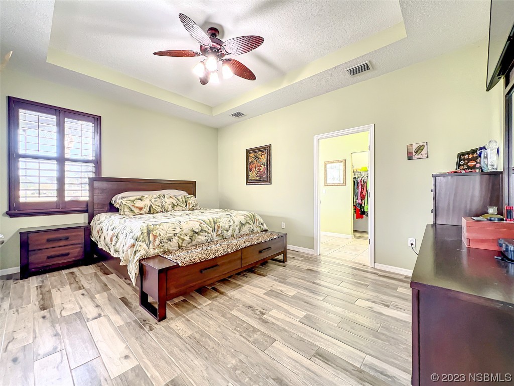 407 Northstar Lane Edgewater, FL 32141 - Photo 24 of 47 a bedroom with a large bed and a chandelier