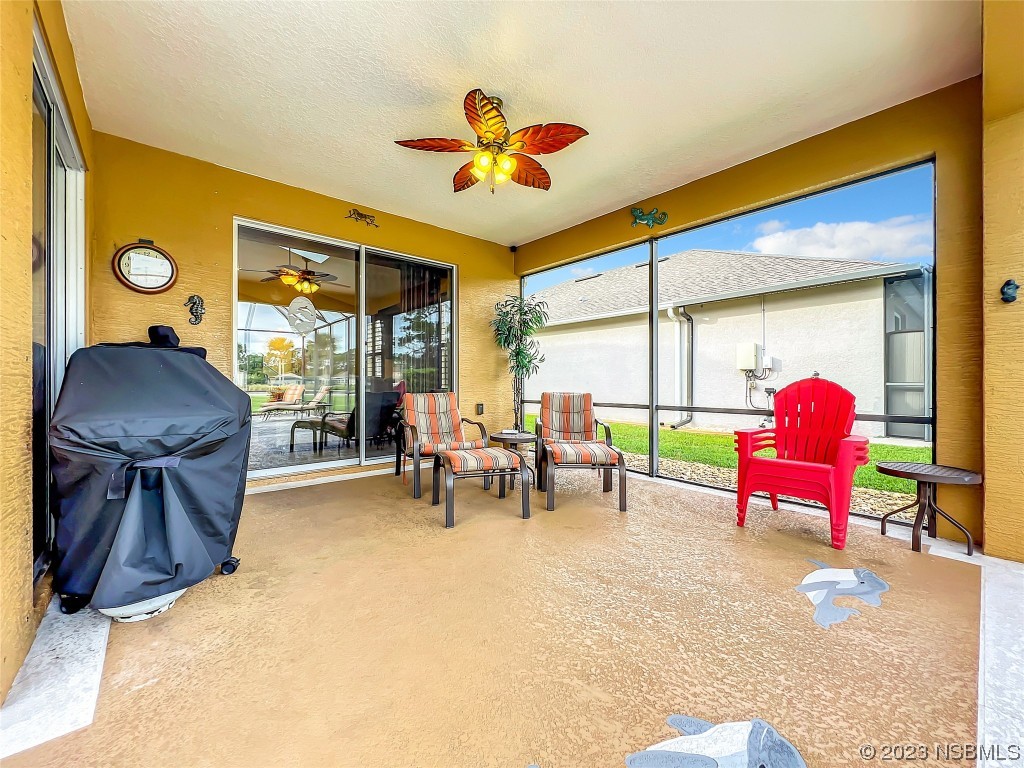 407 Northstar Lane Edgewater, FL 32141 - Photo 36 of 47 a living room with furniture and a floor to ceiling window