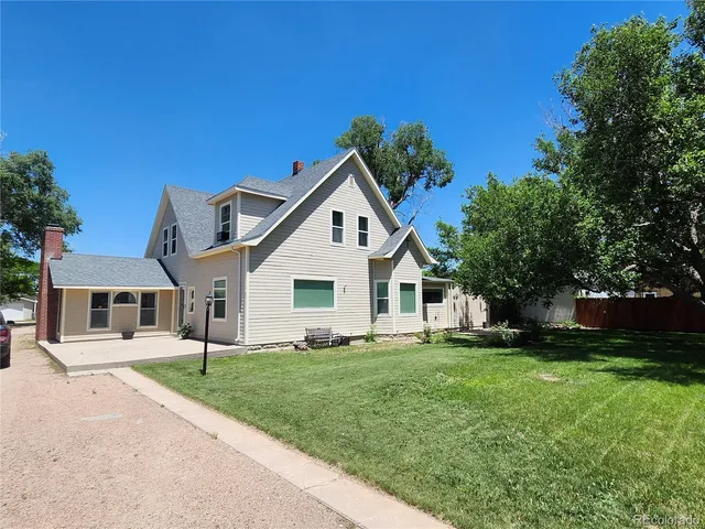 a front view of a house with a garden and yard