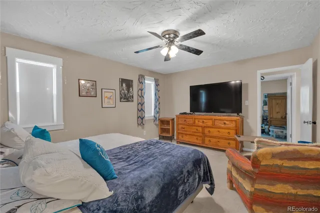 a bedroom with two beds and a ceiling fan