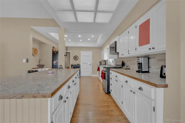 a large kitchen with stainless steel appliances granite countertop a lot of counter space and a sink