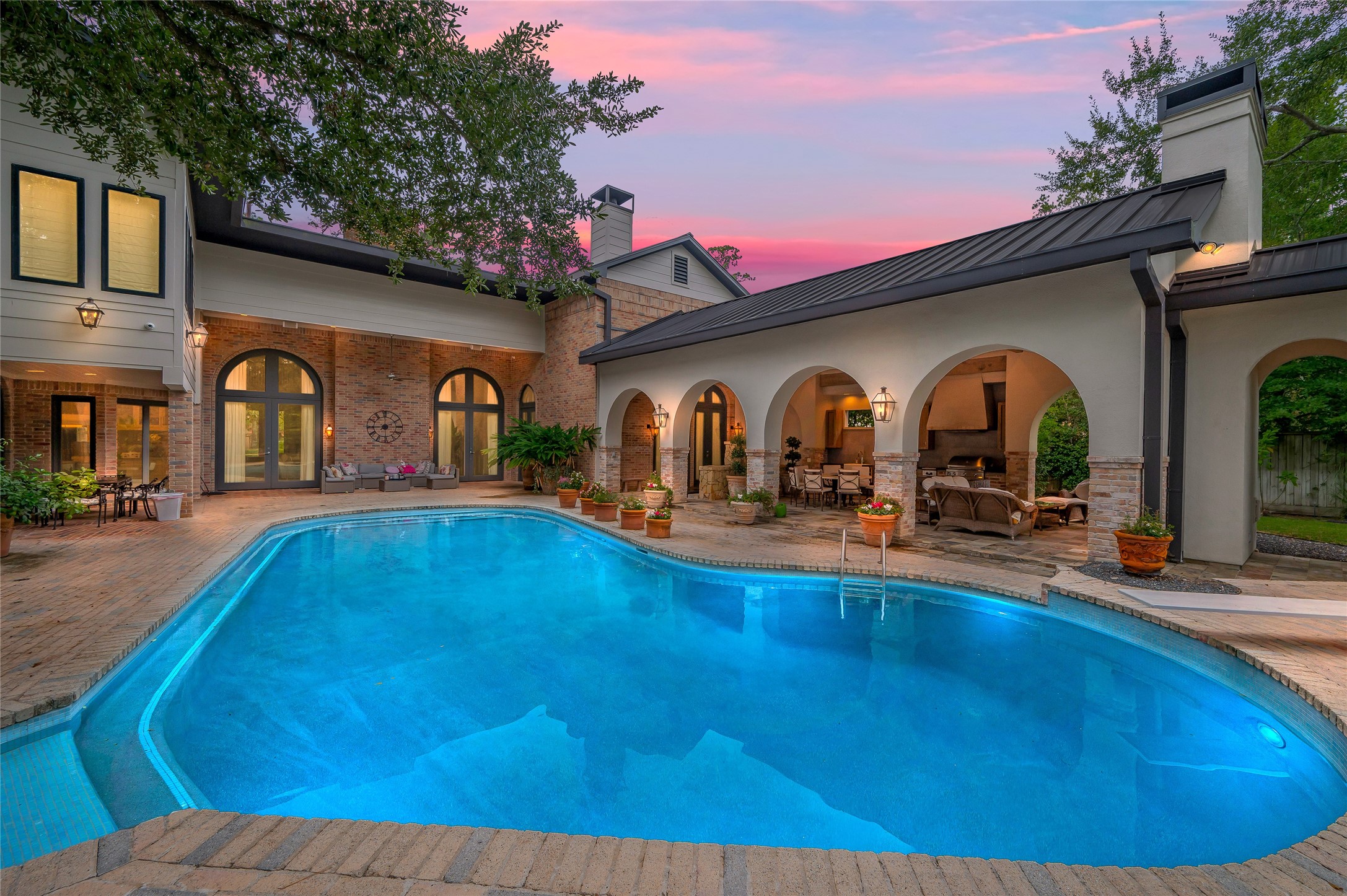 11518 Shadow Way Street Houston, TX 77024 - Photo 2 of 50 Beyond the home awaits a spectacular backyard retreat with a glistening pool, relaxing spa, summer kitchen, and generous lawn space, perfect for entertaining, play, and peaceful moments.