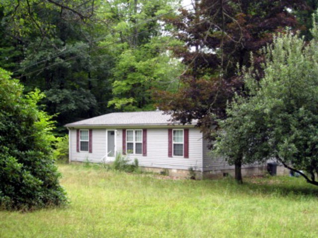 3399 Old Route, Unit 8 Polk, PA 16342 - Photo 1 of 1 a front view of a house with a yard table and chairs