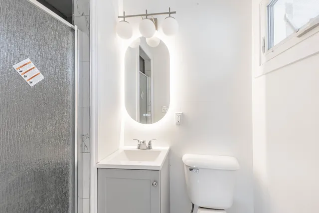 a bathroom with a sink a toilet and a mirror