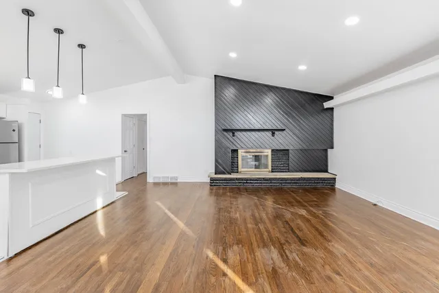 a view of empty room with wooden floor