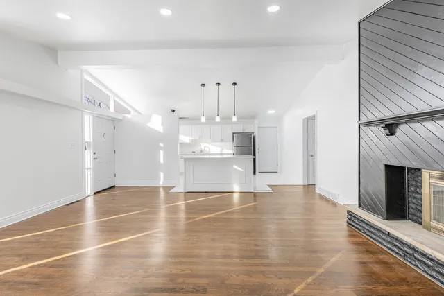 wooden floor in an empty room with a kitchen