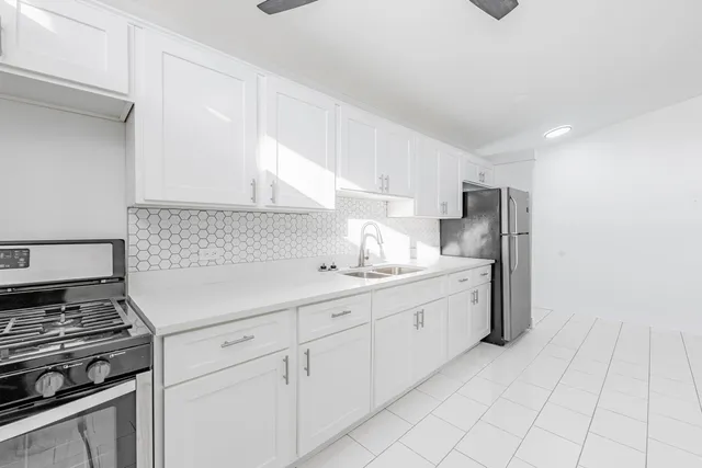 a kitchen with granite countertop white cabinets and white appliances