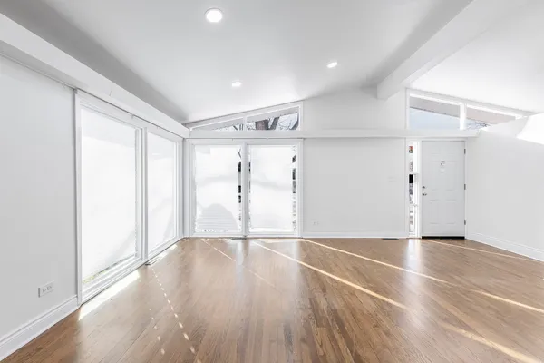 a view of an empty room with wooden floor