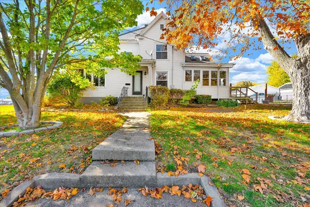 a view of a house with a yard and tree s