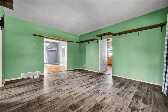 a view of a big room with wooden floor and windows