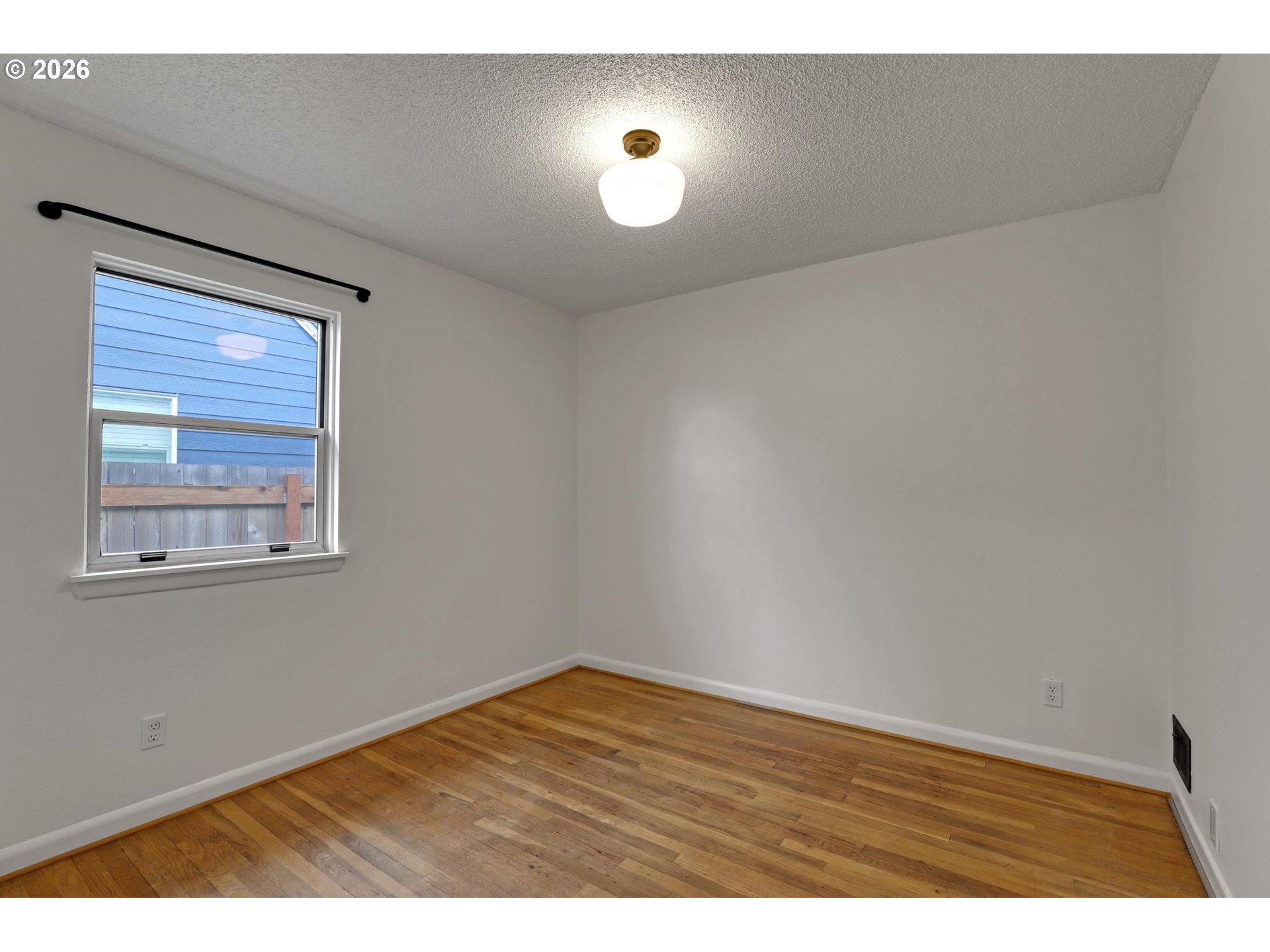 8915 Southeast Market Street Portland, OR 97216 - Photo 12 of 26 a view of an empty room with wooden floor and a window