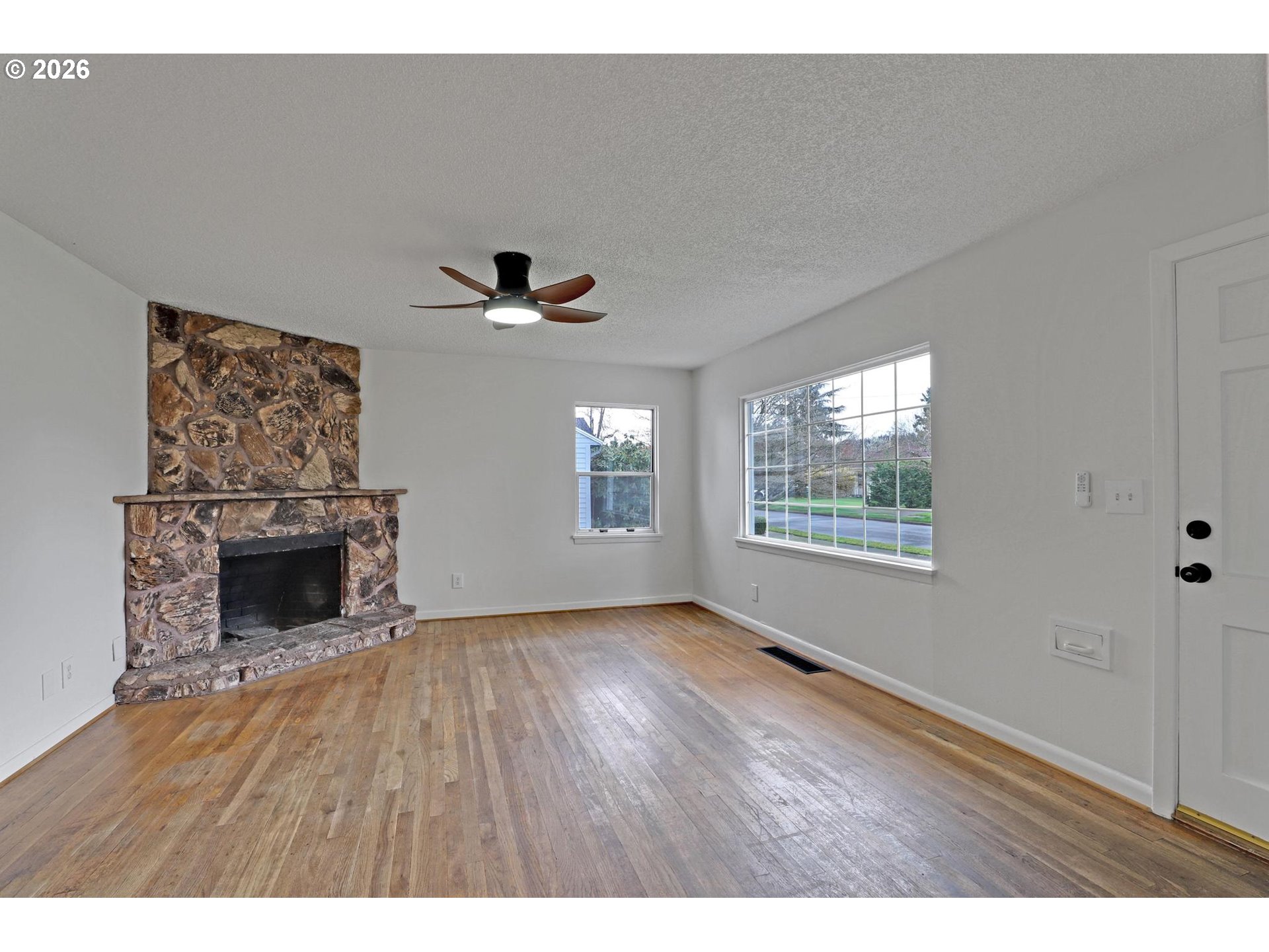 8915 Southeast Market Street Portland, OR 97216 - Photo 4 of 26 a view of an empty room with a window and fireplace