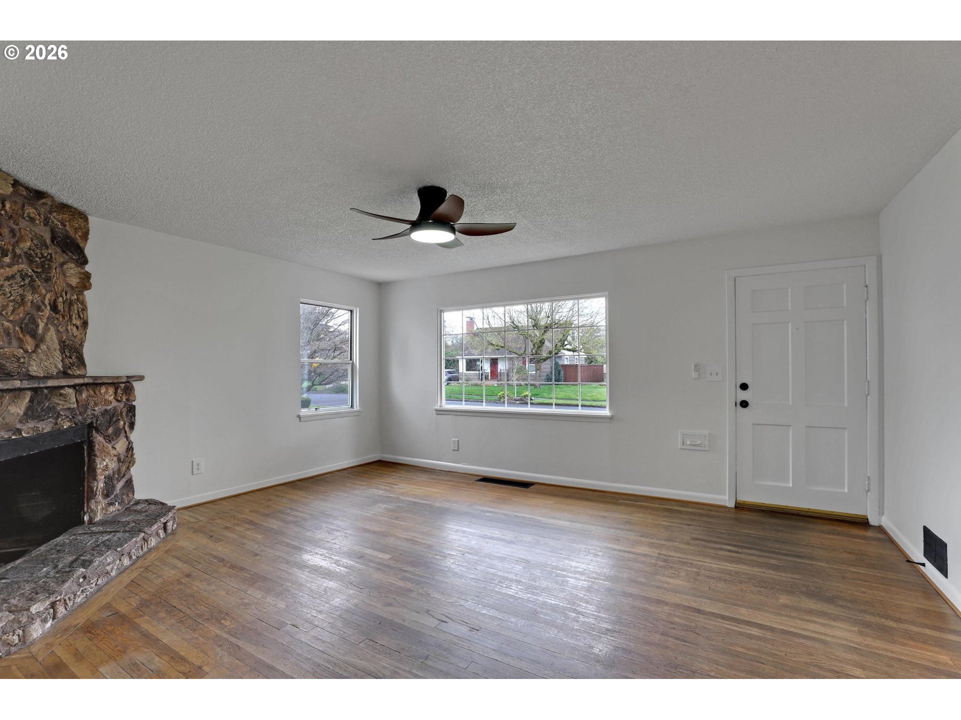 8915 Southeast Market Street Portland, OR 97216 - Photo 5 of 26 a view of an empty room with a window and wooden floor