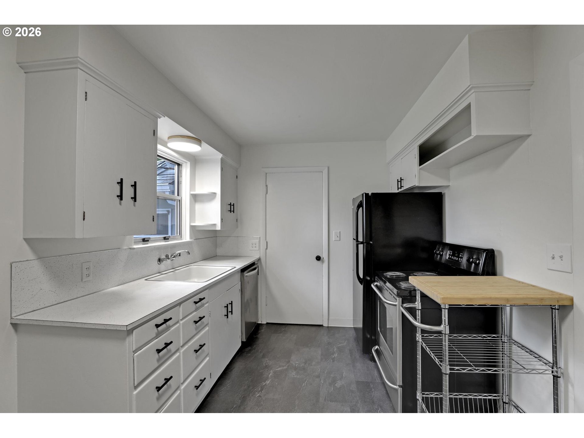 8915 Southeast Market Street Portland, OR 97216 - Photo 6 of 26 a kitchen with a sink cabinets and wooden floor