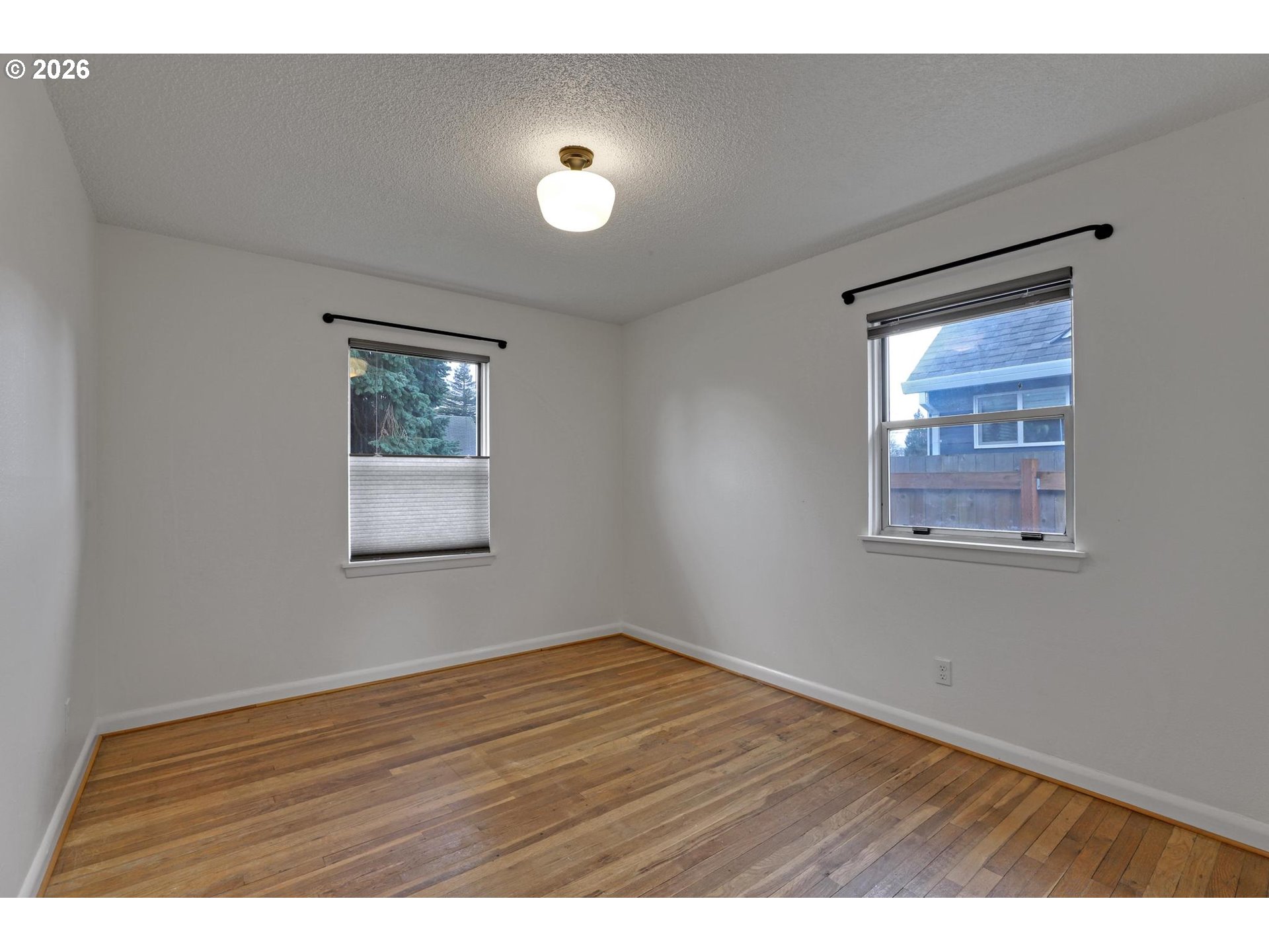 8915 Southeast Market Street Portland, OR 97216 - Photo 10 of 26 a view of an empty room with wooden floor and a window