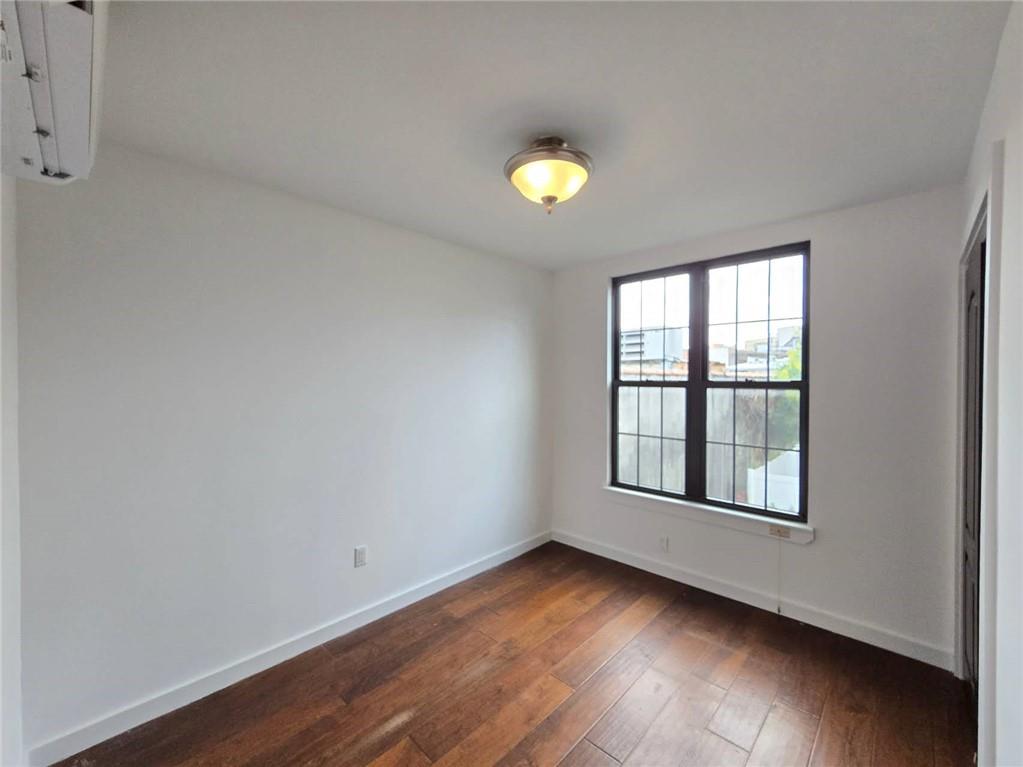 151 Noll Street Brooklyn, NY 11206 - Photo 11 of 30 an empty room with wooden floor and windows