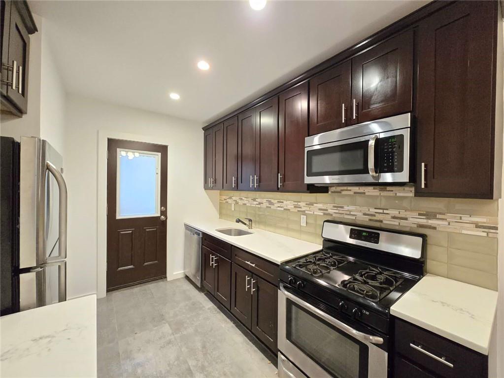 151 Noll Street Brooklyn, NY 11206 - Photo 15 of 30 a kitchen with stainless steel appliances granite countertop wooden cabinets a stove top oven a sink and dishwasher