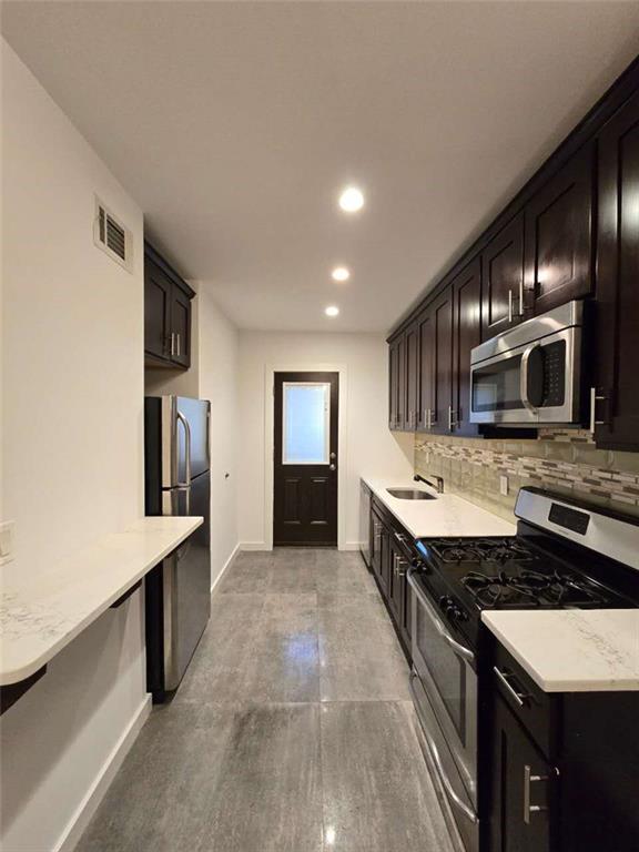 151 Noll Street Brooklyn, NY 11206 - Photo 17 of 30 a large kitchen with a large counter top stainless steel appliances and cabinets