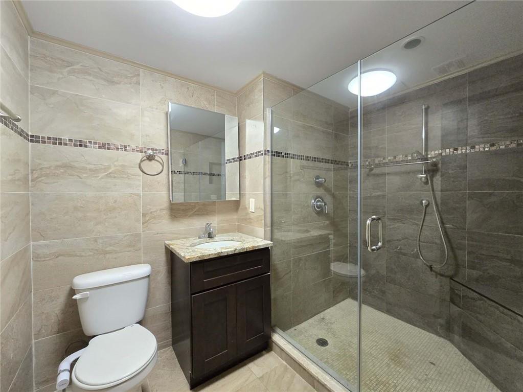 151 Noll Street Brooklyn, NY 11206 - Photo 21 of 30 a bathroom with a granite countertop sink a toilet and shower