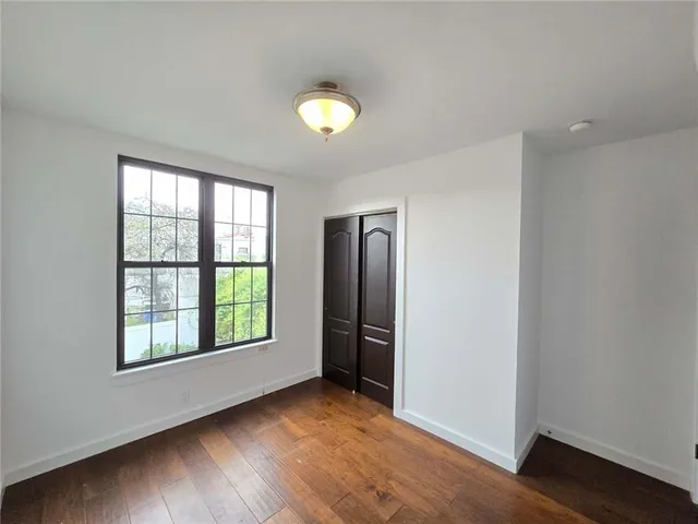 an empty room with windows and closet