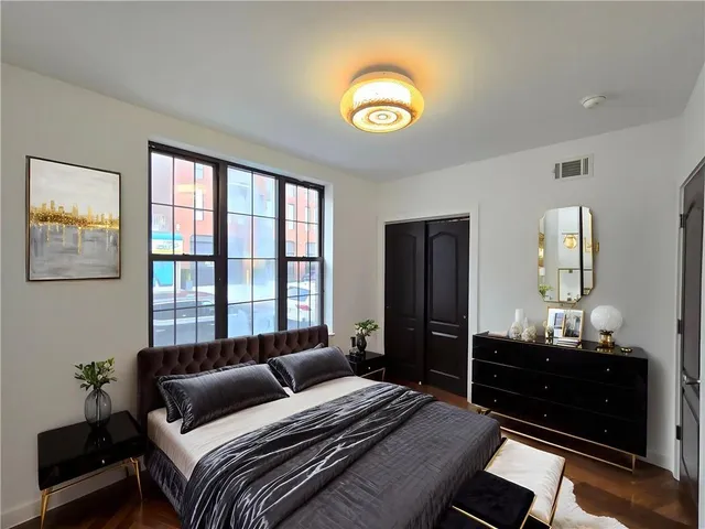 a bedroom with a bed and wooden floor