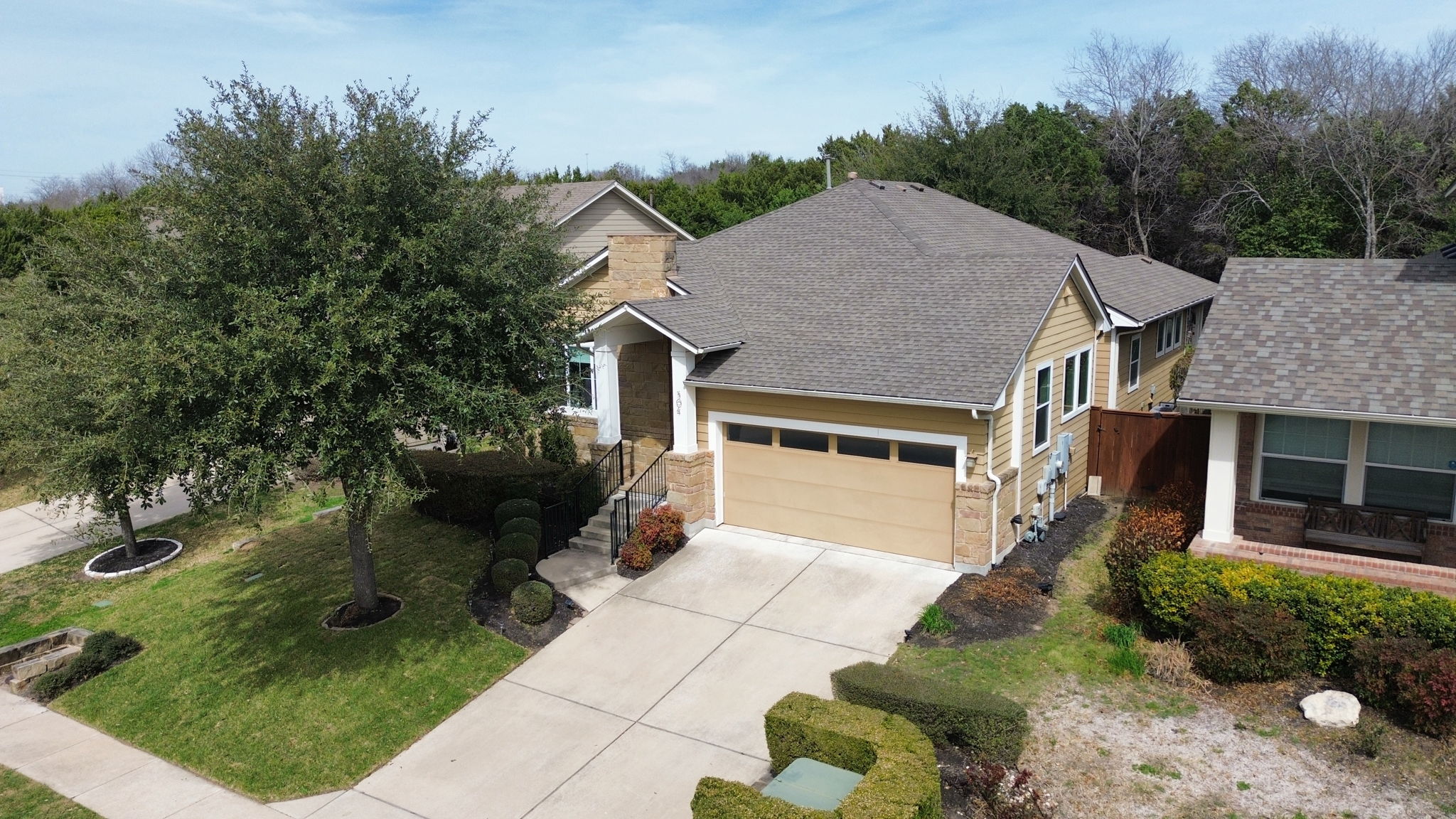 View of front of property featuring a garage, concrete driveway, roof with shingles, brick siding, and a front lawn