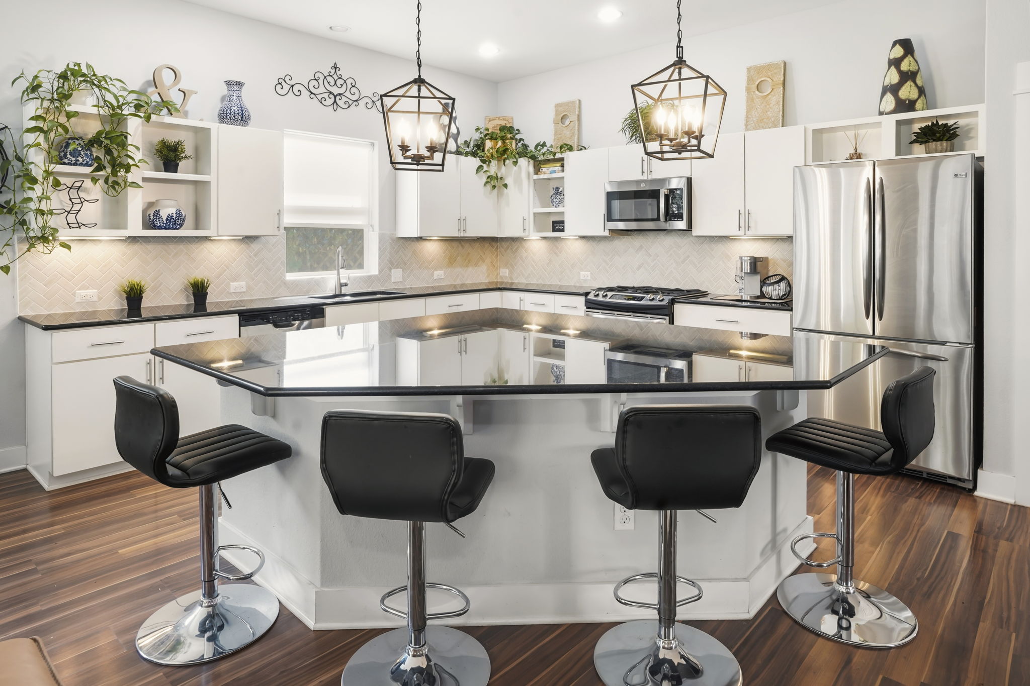 504 Bowery Trail Austin, TX 78753 - Photo 14 of 38 Kitchen with open shelves, stainless steel appliances, white cabinetry, a center island, and a breakfast bar