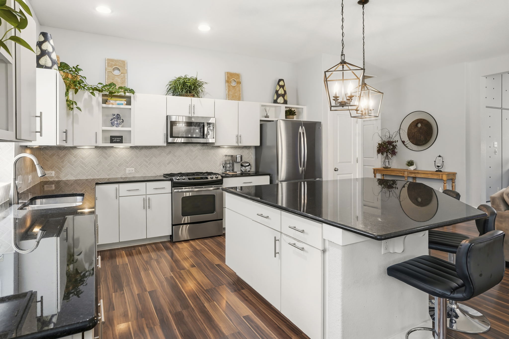 504 Bowery Trail Austin, TX 78753 - Photo 15 of 38 Kitchen featuring open shelves, a kitchen island, stainless steel appliances, and white cabinets