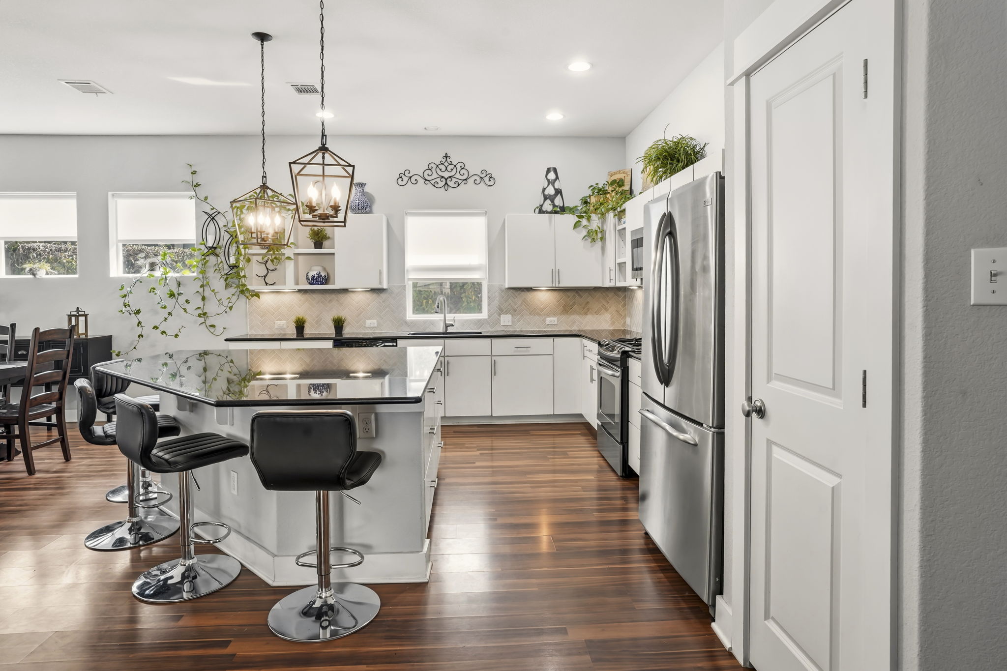 504 Bowery Trail Austin, TX 78753 - Photo 16 of 38 Kitchen featuring a breakfast bar, a kitchen island, stainless steel appliances, white cabinetry, and hanging light fixtures