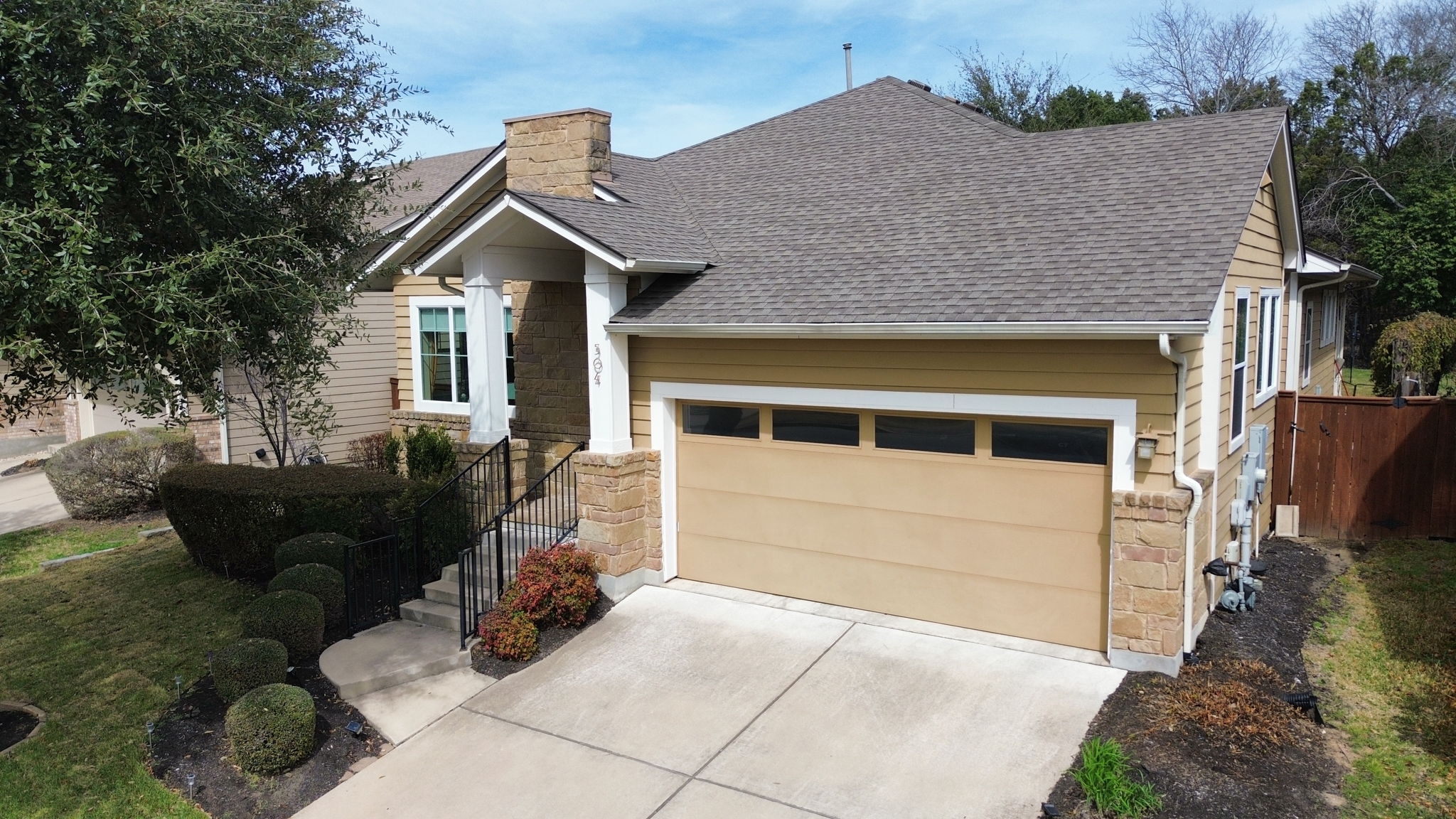504 Bowery Trail Austin, TX 78753 - Photo 2 of 38 View of front of house with stone siding, a garage, roof with shingles, concrete driveway, and a chimney