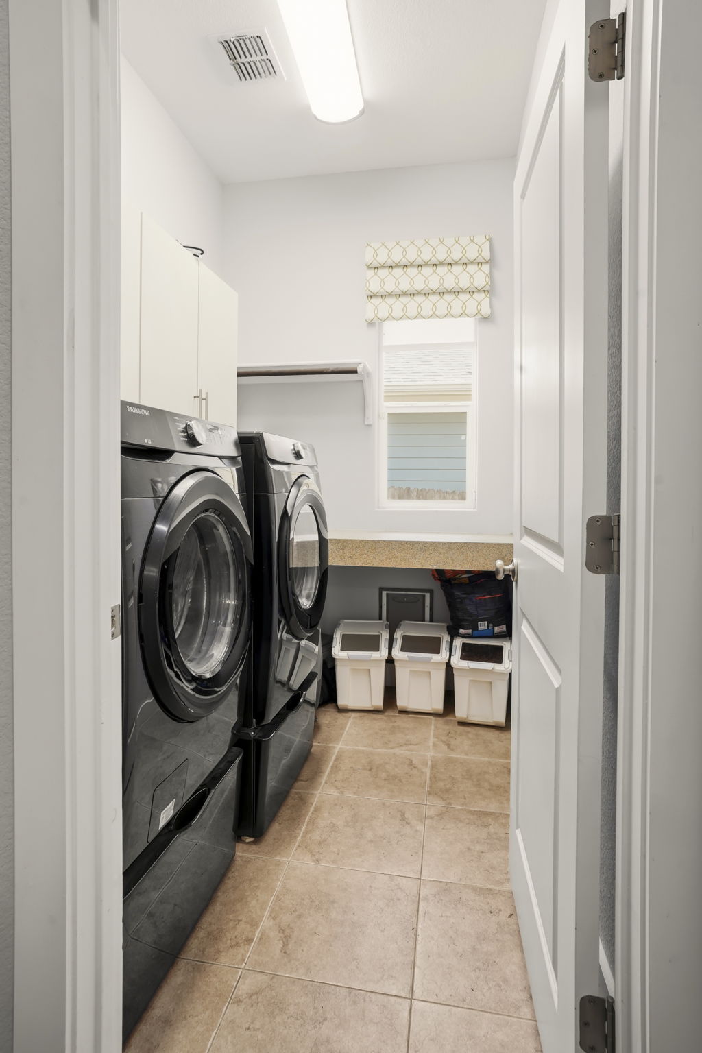 504 Bowery Trail Austin, TX 78753 - Photo 27 of 38 Laundry area with light tile patterned flooring, separate washer and dryer, and cabinet space