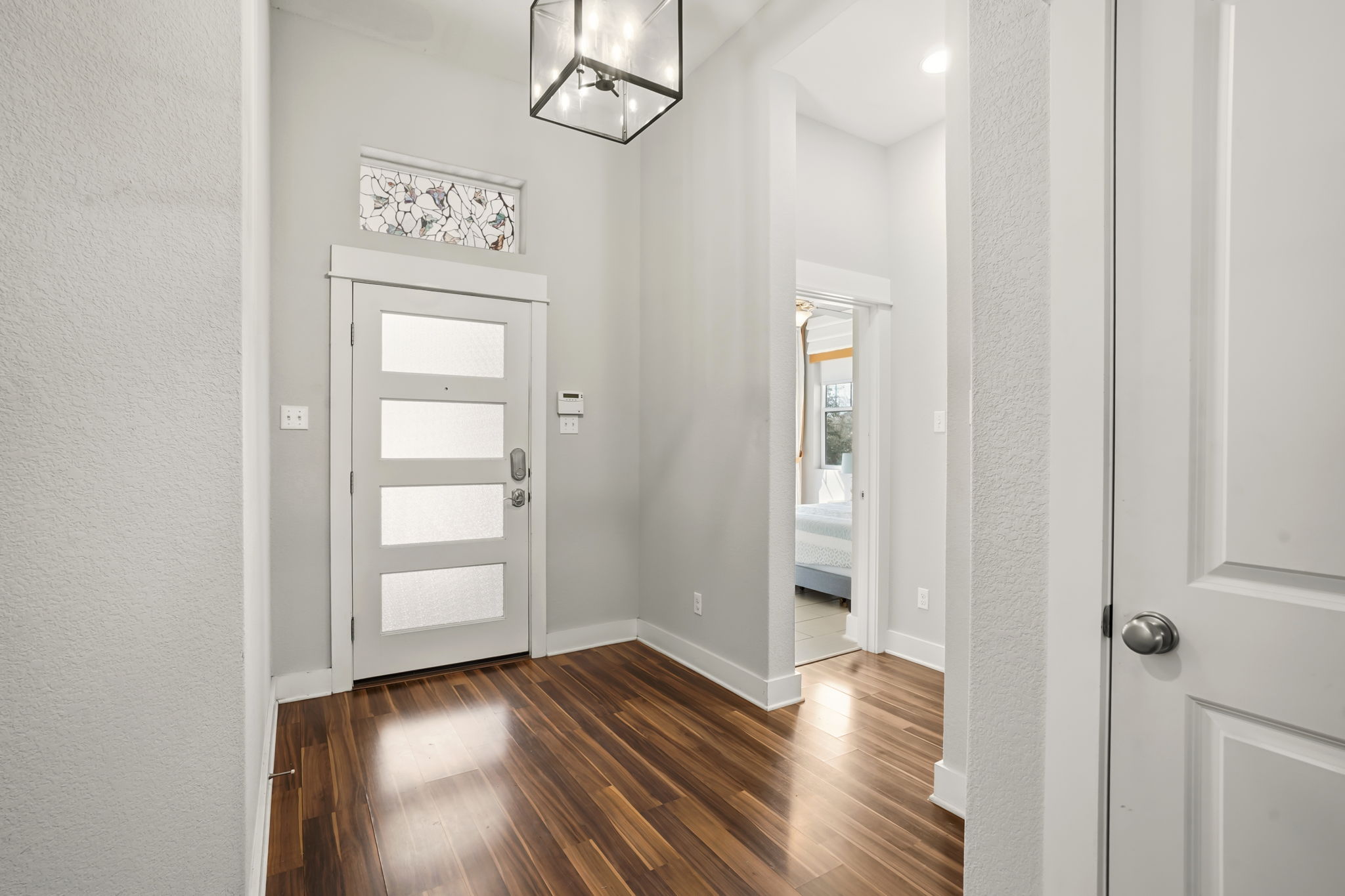 504 Bowery Trail Austin, TX 78753 - Photo 29 of 38 Entryway featuring dark wood-style flooring, hanging lights, and a textured wall