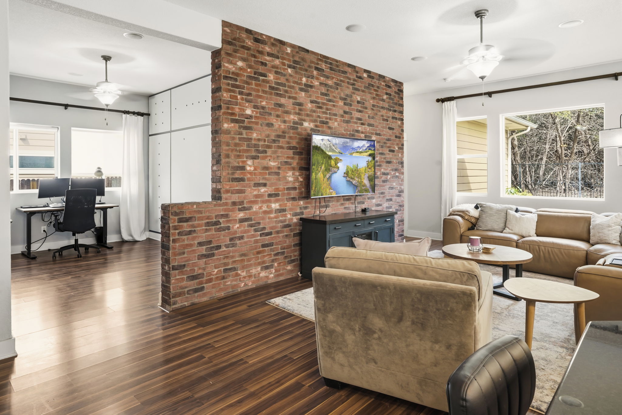 504 Bowery Trail Austin, TX 78753 - Photo 9 of 38 Living room with a ceiling fan, a desk, dark wood finished floors, and brick wall