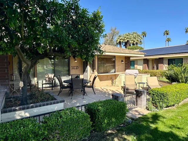 a view of a house with backyard sitting area and garden