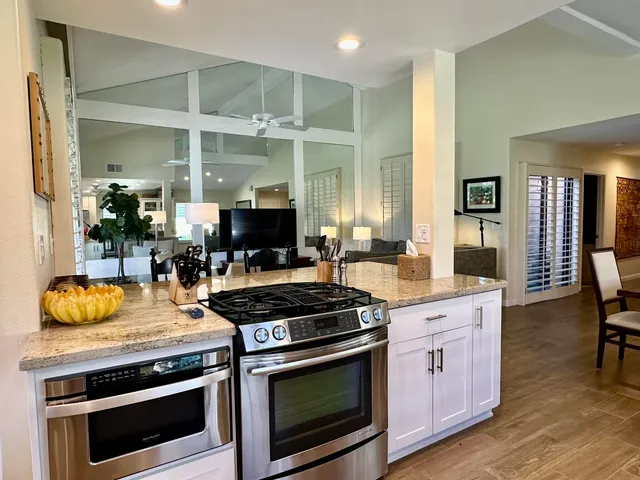 a kitchen with granite countertop a stove and a wooden floors